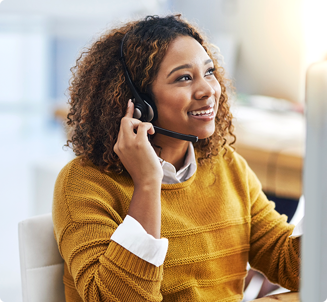 Customer Service Representative with headset on, smiling and enjoying her role in customer service.